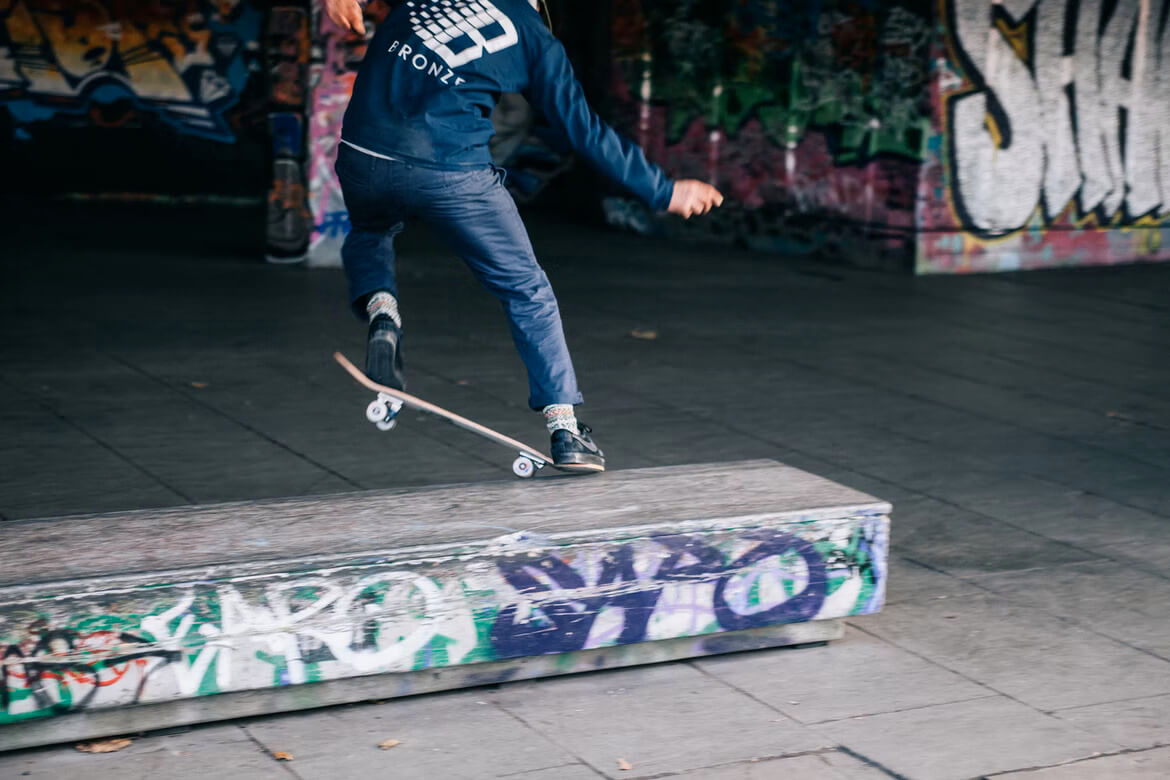 Man performing a skateboard trick in an urban skatepark