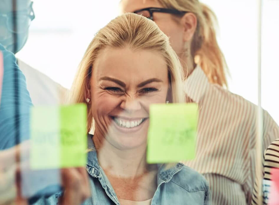 Woman smiling looking at post-it note