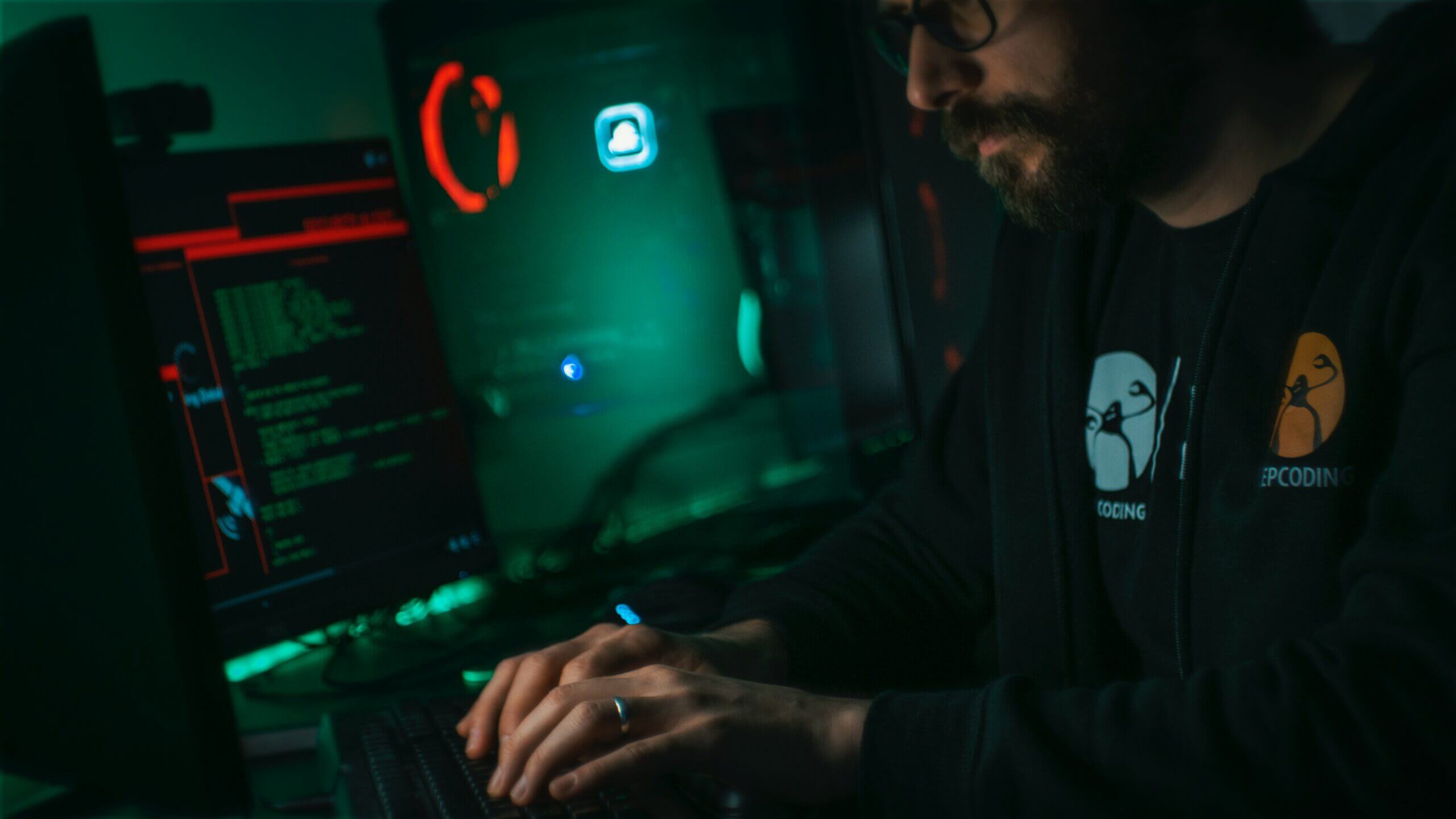 Dark image of man hacking on a computer